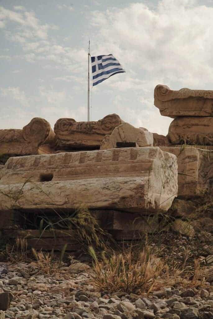 Greek flag flying over the Acropolis ruins