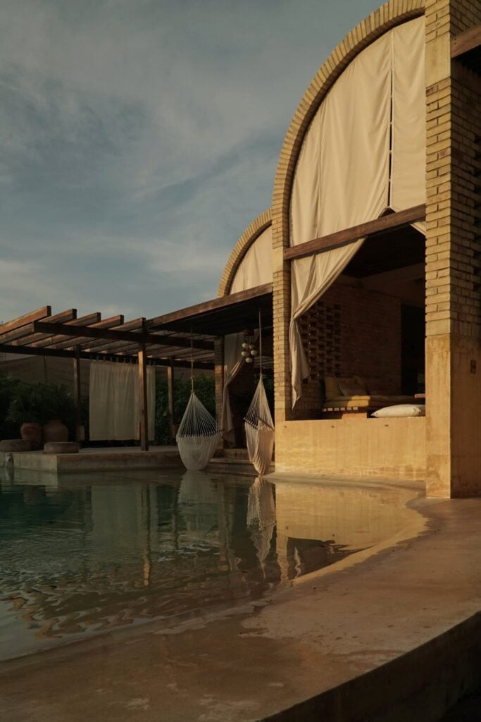 Hanging hammock chairs reflected in the pool at Casona Sforza